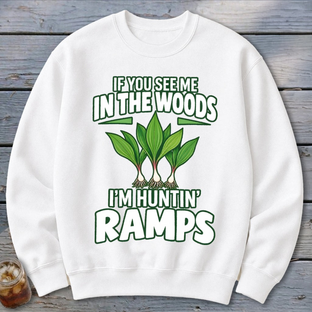 A white crewneck sweatshirt features green text and an illustration of three ramp plants with the words "IF YOU SEE ME IN THE WOODS I'M HUNTIN' RAMPS".