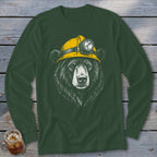 Black bear wearing a yellow hard hat with a headlamp on a green long-sleeve shirt.