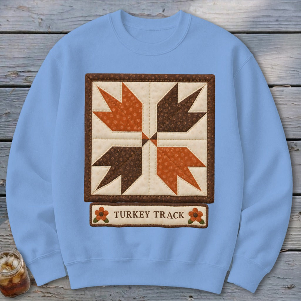Light blue sweatshirt with a quilted "Turkey Track" block design and text.