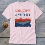 A light pink t-shirt with patriotic graphics featuring the text Stars, Stripes and Sweet Tea.