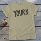 Tan t-shirt with "YOUR'N" in dark gray text.