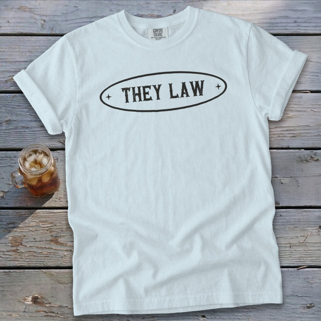 White t-shirt with oval graphic and "THEY LAW" text.