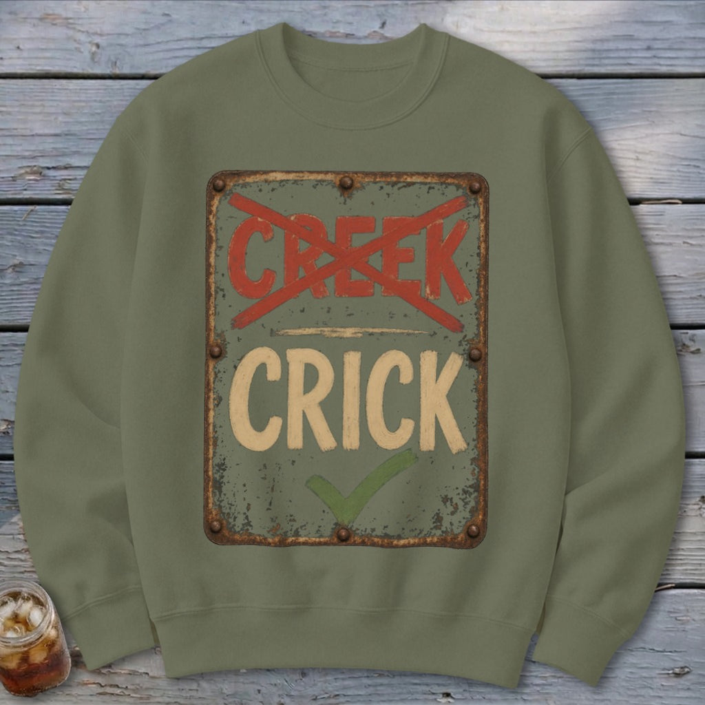 Green sweatshirt with a distressed sign saying "CRICK" with a checkmark, and "CREEK" crossed out.
