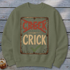Green sweatshirt with a distressed sign saying "CRICK" with a checkmark, and "CREEK" crossed out.