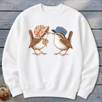 White sweatshirt with two wrens, one wearing a bonnet, the other a striped cap.