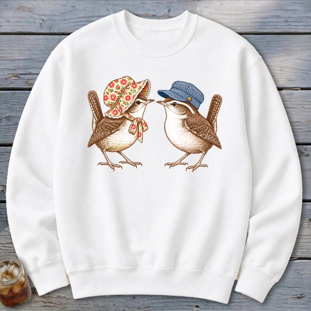 White sweatshirt with two wrens, one wearing a bonnet, the other a striped cap.