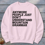 Pink sweatshirt with black text reading "Anymore people just don't understand mountain grammar."