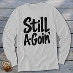 Light gray long-sleeved crewneck shirt with black text reading "Still A-Goin'".