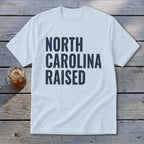 White t-shirt with "NORTH CAROLINA RAISED" text and a glass of iced tea.