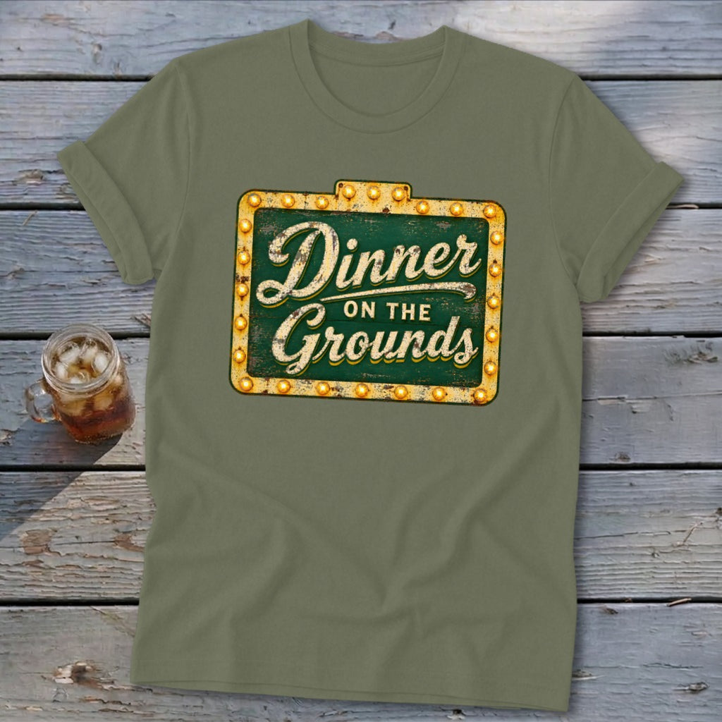 Olive green t-shirt featuring a vintage marquee sign graphic that reads Dinner on the Grounds.