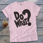 Light pink crewneck t-shirt with black text reading "Do What?" and a glass of iced tea on a weathered wooden background.