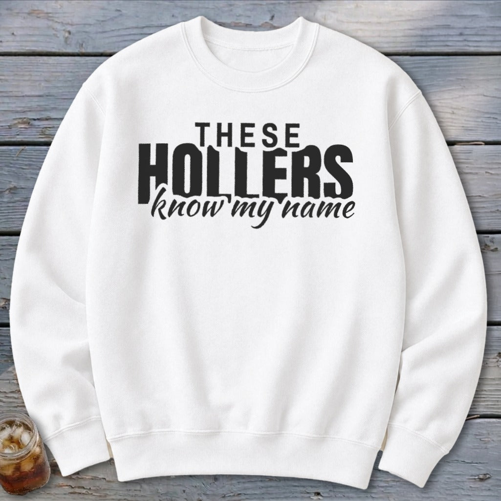 White sweatshirt with black text "THESE HOLLERS know my name."