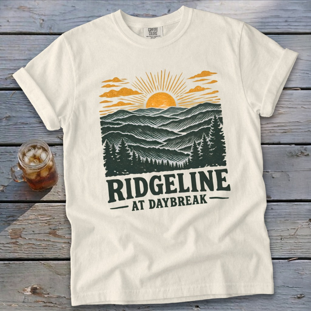 Cream t-shirt with "RIDGELINE AT DAYBREAK" landscape graphic.