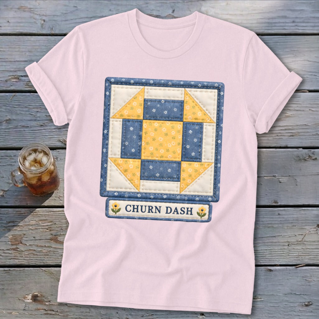 Pink t-shirt with a "Churn Dash" quilt block graphic and a glass of iced tea.