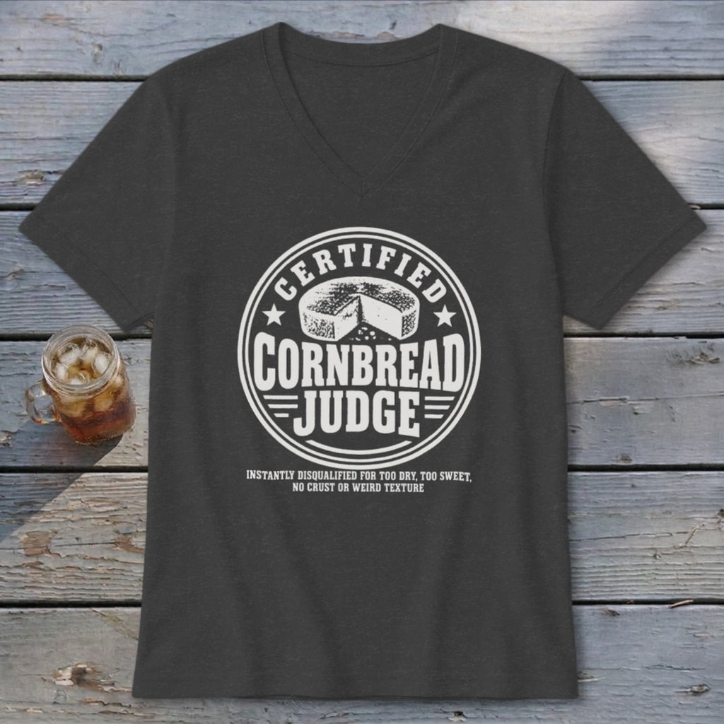 A dark gray v-neck t-shirt with white graphic text reading Certified Cornbread Judge and a round cheese illustration.