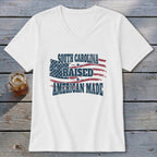 White t-shirt with "South Carolina Raised American Made" text and distressed US flag graphic.