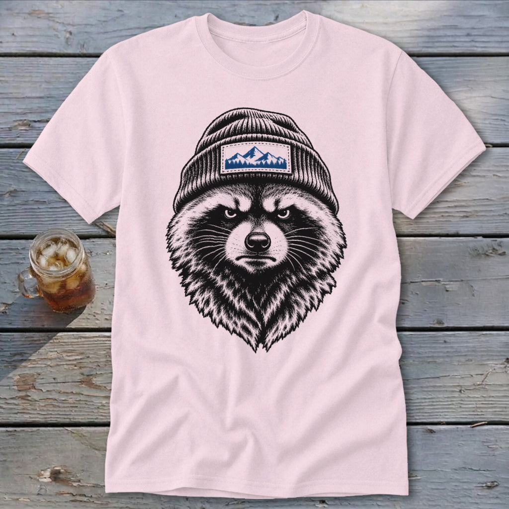 Pink t-shirt with a black and white illustration of a raccoon wearing a beanie with mountains.