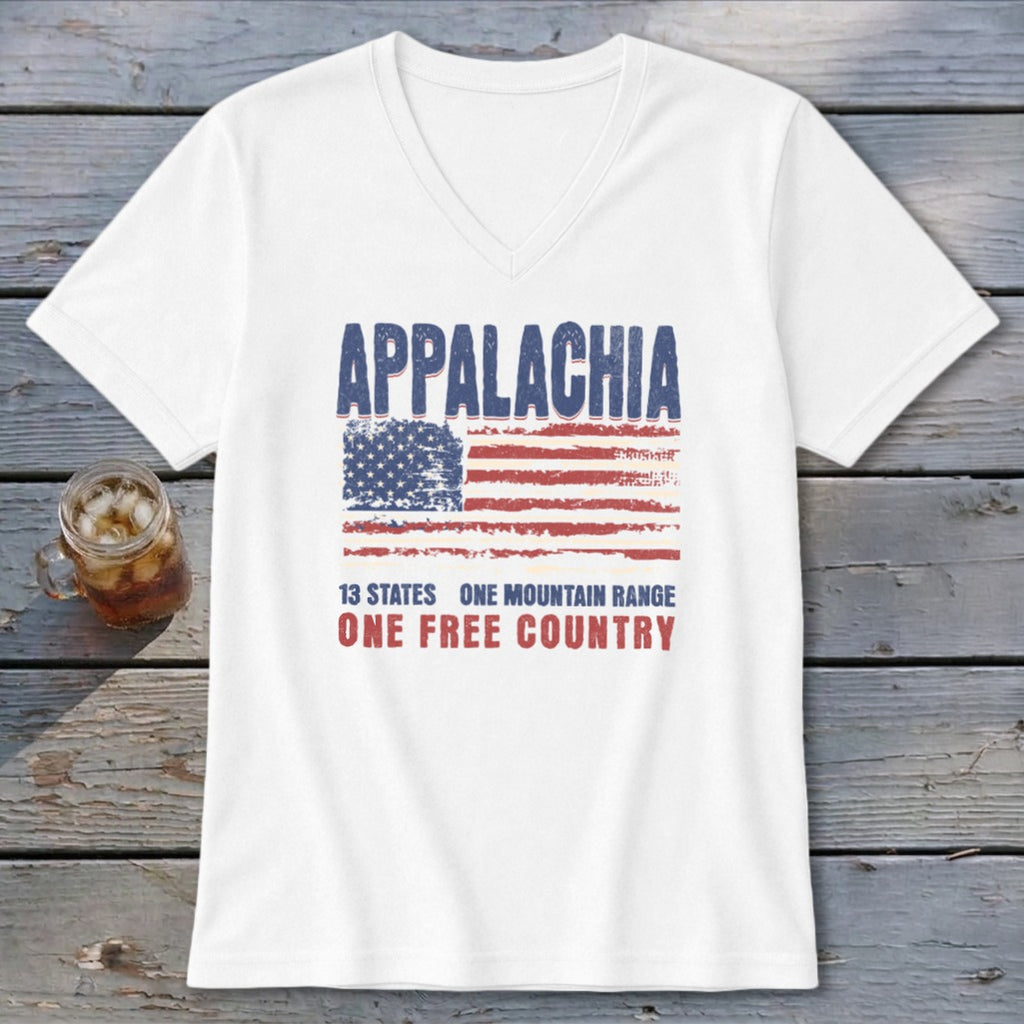 A white V-neck t-shirt featuring a distressed American flag graphic and Appalachia text on a wooden surface.