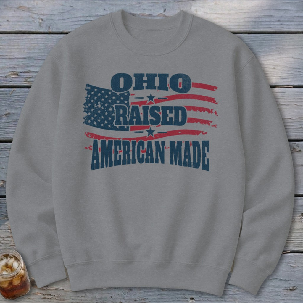 Gray crewneck sweatshirt with distressed graphic text reading Ohio Raised American Made over an American flag.