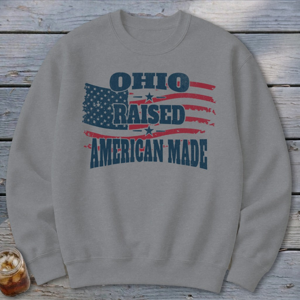 Gray crewneck sweatshirt with distressed graphic text reading Ohio Raised American Made over an American flag.