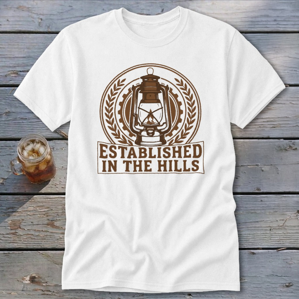White t-shirt with a brown lantern emblem and "ESTABLISHED IN THE HILLS" text.
