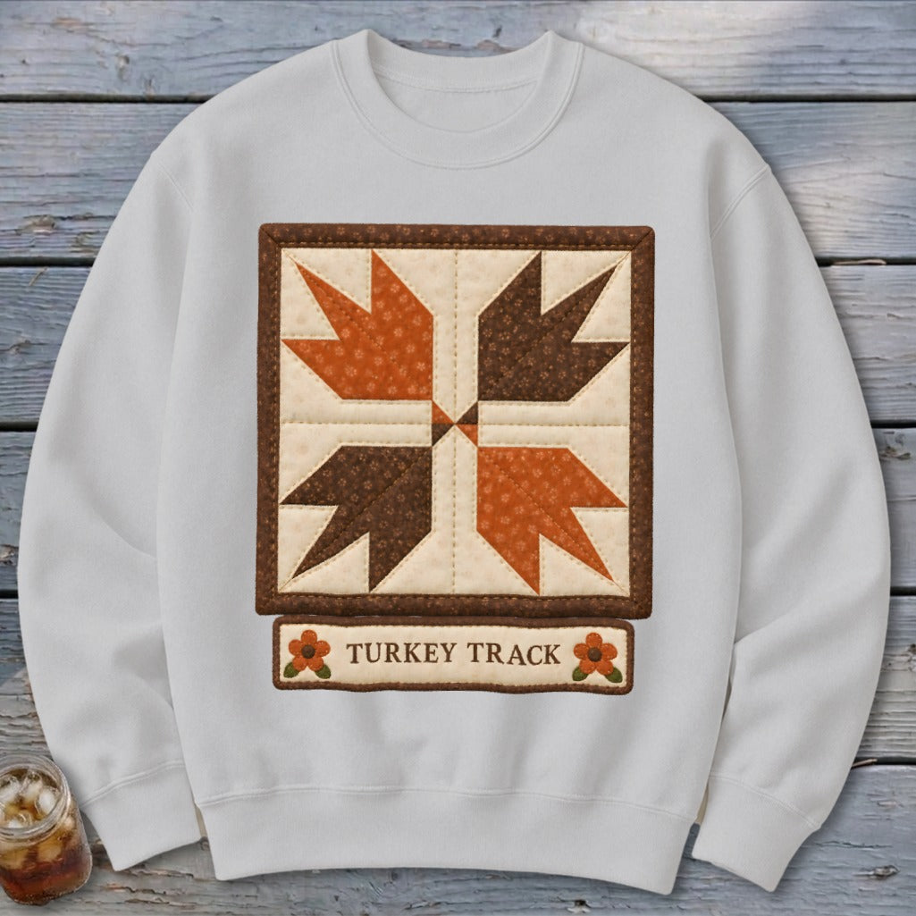 White sweatshirt featuring a "Turkey Track" quilt square design with text.