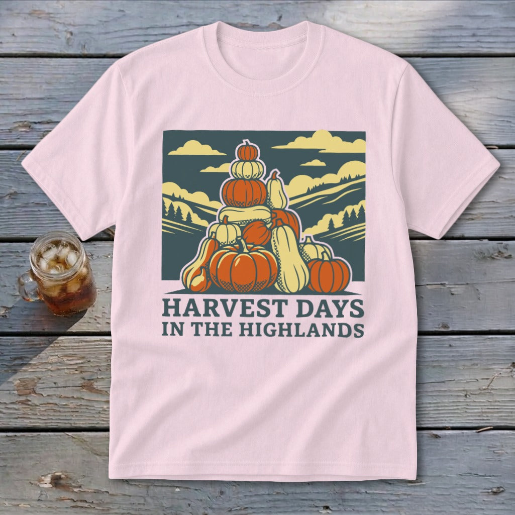 Light pink t-shirt featuring a graphic of stacked pumpkins, hills, and the text Harvest Days in the Highlands.