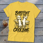 Yellow t-shirt with "Barefoot on the Crick Bank" text and illustration of feet in water.