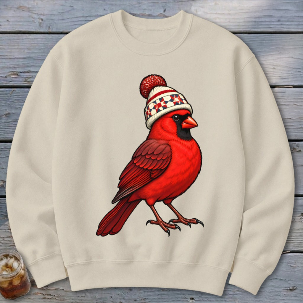 Beige crewneck sweatshirt featuring a graphic of a red cardinal wearing a winter beanie.