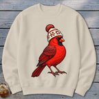 Beige crewneck sweatshirt featuring a graphic of a red cardinal wearing a winter beanie.