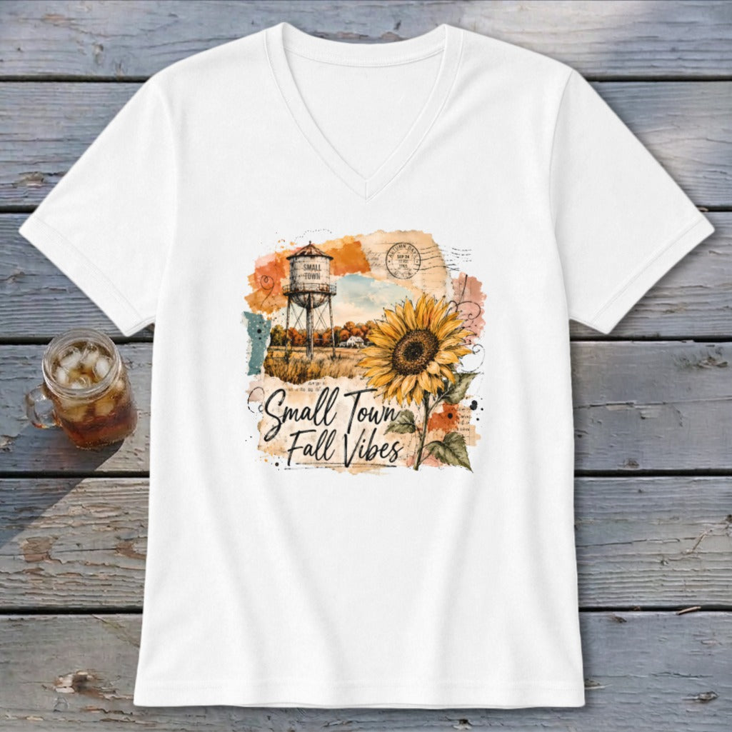 White v-neck shirt with "Small Town Fall Vibes" graphic featuring a sunflower and water tower.