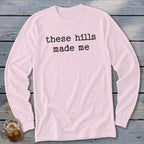 Light pink long-sleeve shirt with black text that reads "these hills made me".