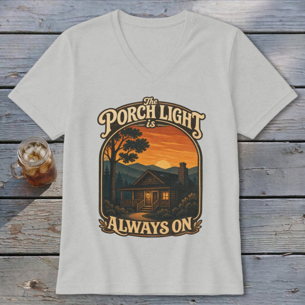 The Porch Light is Always On cabin graphic on a light gray v-neck t-shirt.