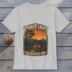 The Porch Light is Always On cabin graphic on a light gray v-neck t-shirt.