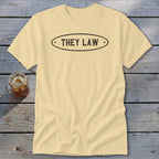 Pale yellow t-shirt with black text "THEY LAW" inside an oval.