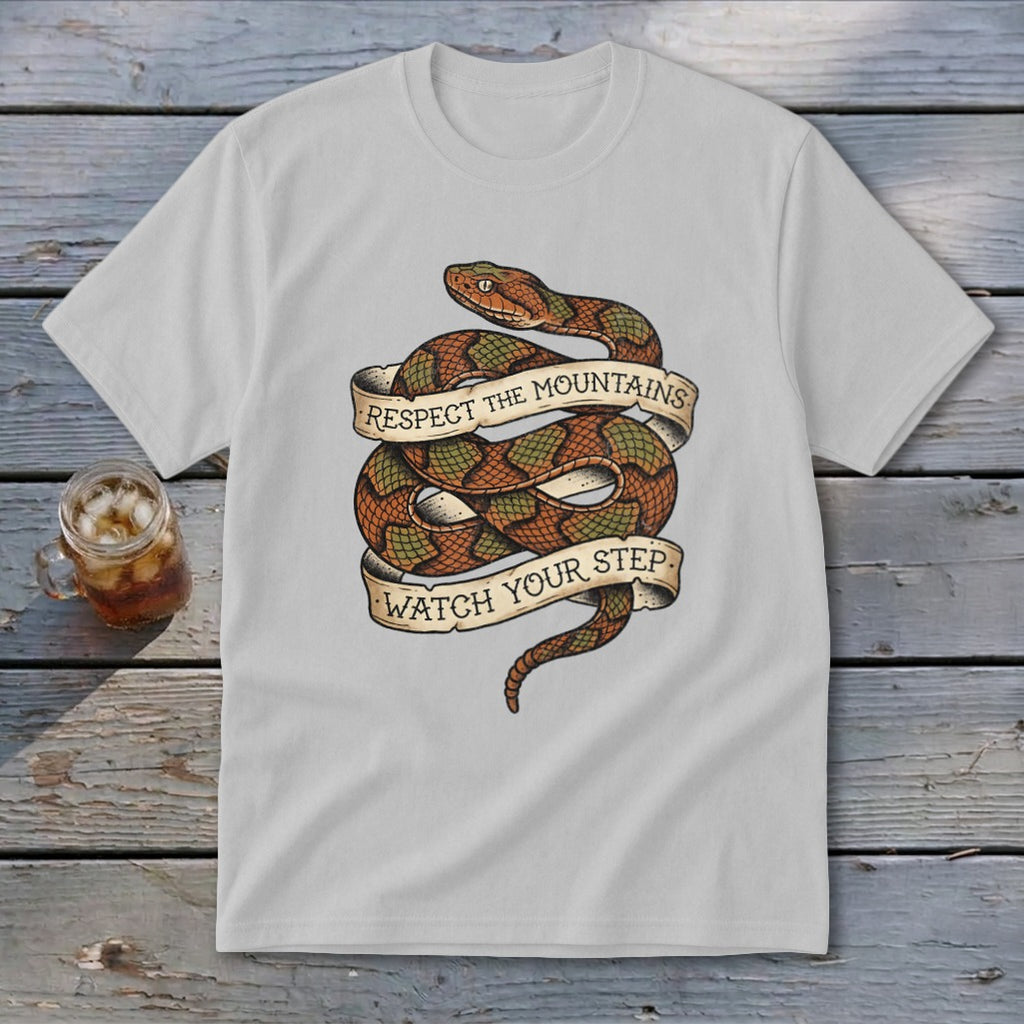 White t-shirt with coiled snake graphic and banner text "Respect the Mountains Watch Your Step".