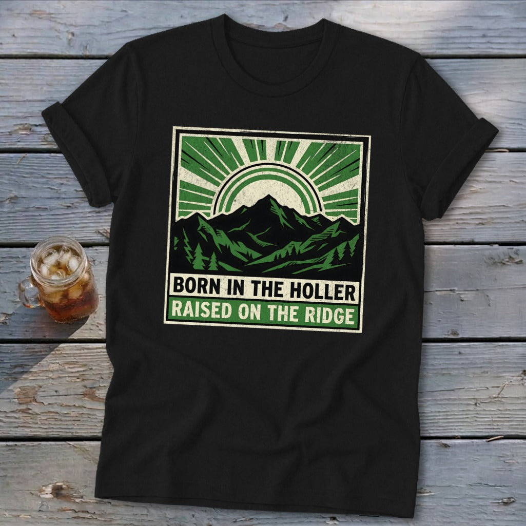 Black t-shirt featuring a green graphic of mountains and text reading Born in the Holler Raised on the Ridge.