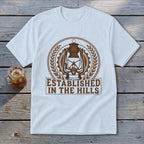White t-shirt with brown graphic of a lantern and "Established In The Hills" text.