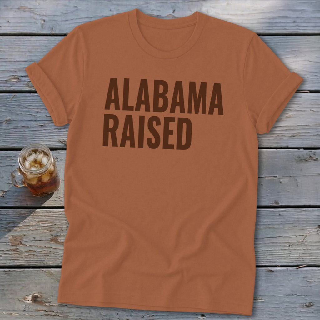Orange t-shirt with "Alabama Raised" text in brown and a glass of iced tea.