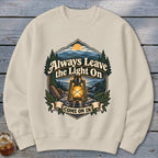 Crewneck sweatshirt with a graphic of a lantern, mountains, and text "Always Leave the Light On Come On In".