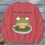 A coral crewneck sweatshirt features an illustrated frog on a lily pad with the text finer than frog's hair.