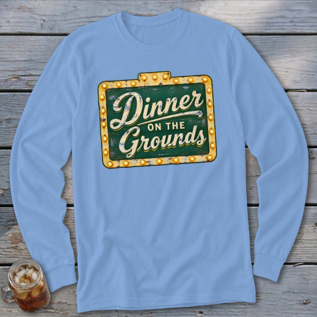 Light blue long-sleeve t-shirt with a distressed marquee sign graphic reading Dinner on the Grounds.