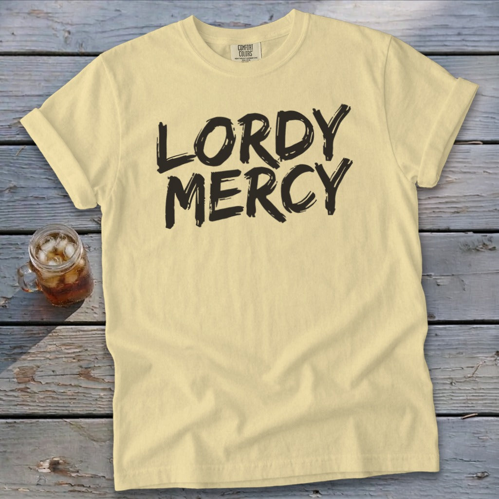 Yellow t-shirt with black text "LORDY MERCY" and a glass of iced tea.