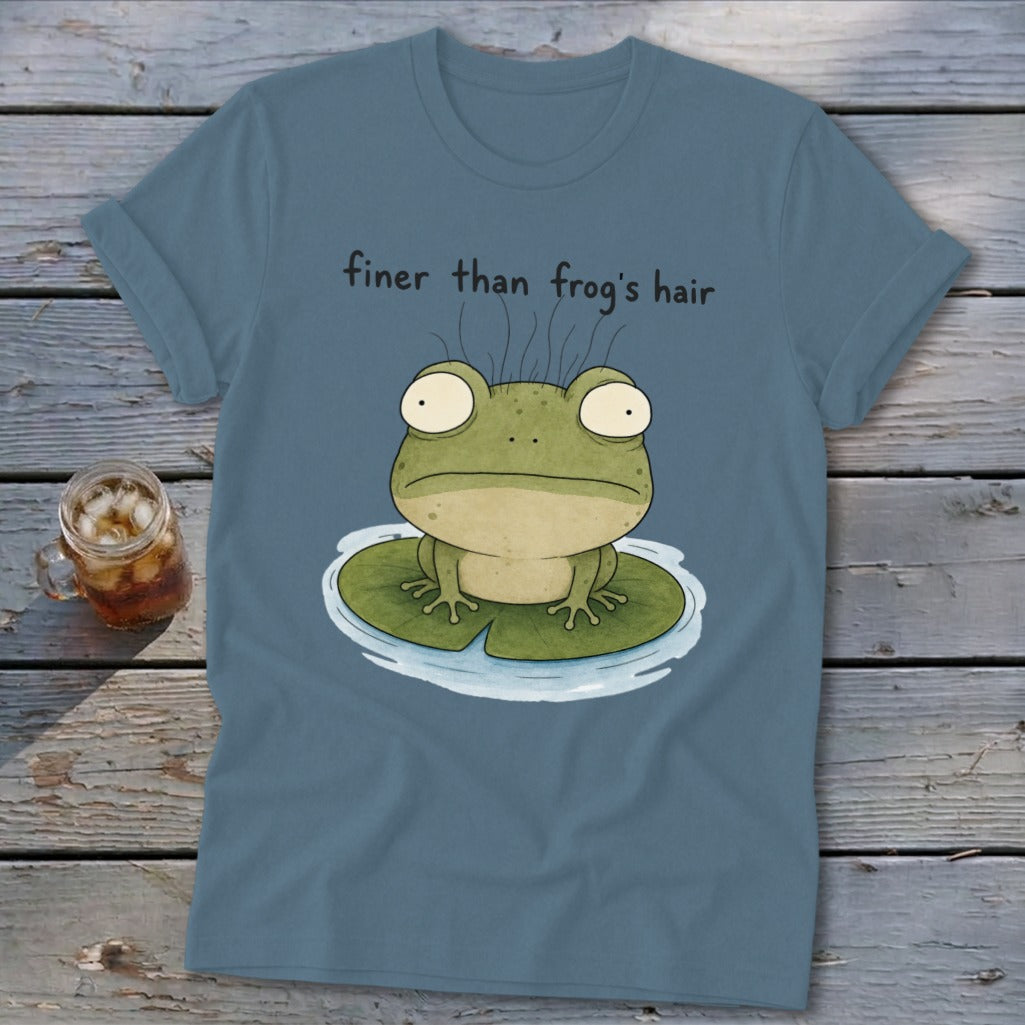 A blue t-shirt printed with a cartoon frog on a lily pad and the text "finer than frog's hair".