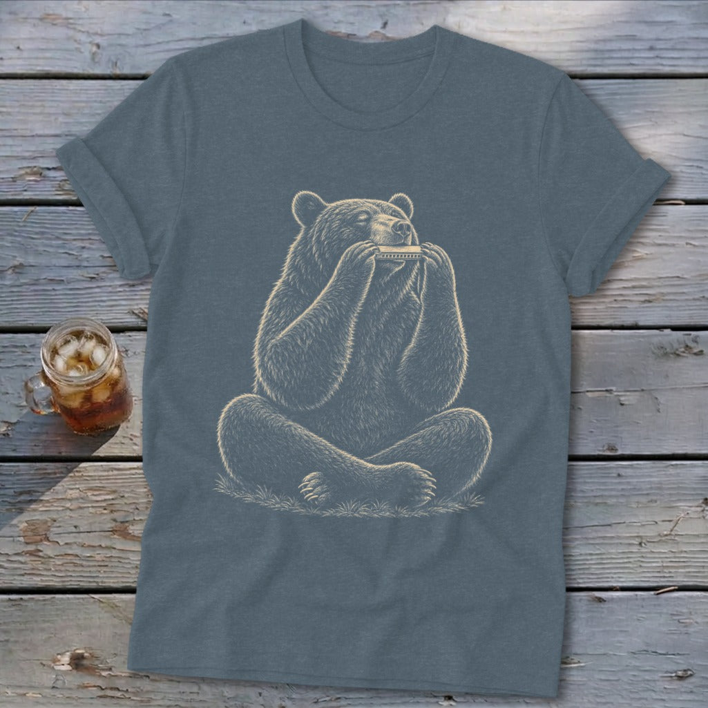 Bear playing a harmonica while sitting cross-legged on grass.