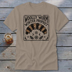 Tan t-shirt featuring a black and tan block-print graphic of a woolly worm with text reading WOLLY WORM WINTER PROPHET.