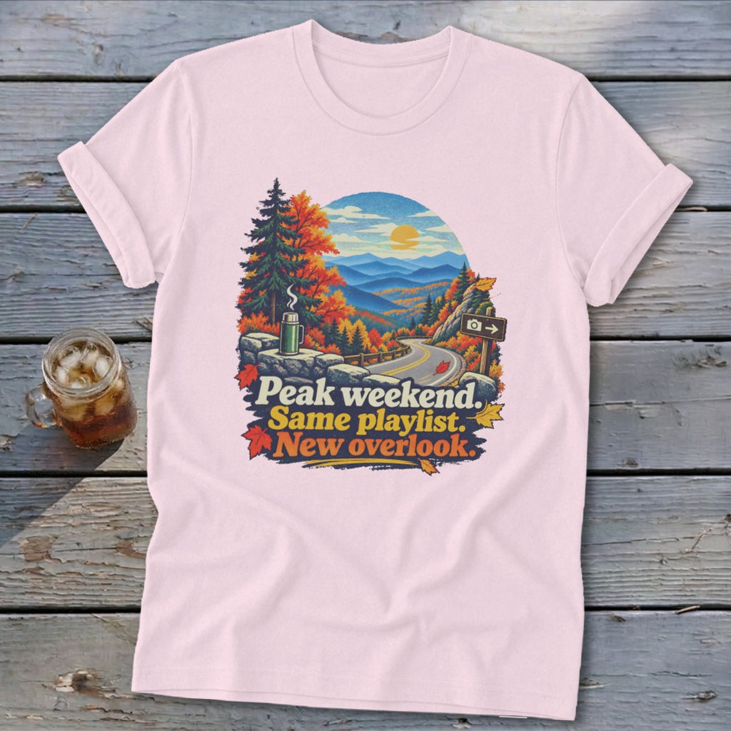 T-shirt graphic with autumn mountain scenery and text: Peak weekend. Same playlist. New overlook.