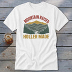 White t-shirt featuring a retro mountain graphic with the text "MOUNTAIN RAISED HOLLER MADE."