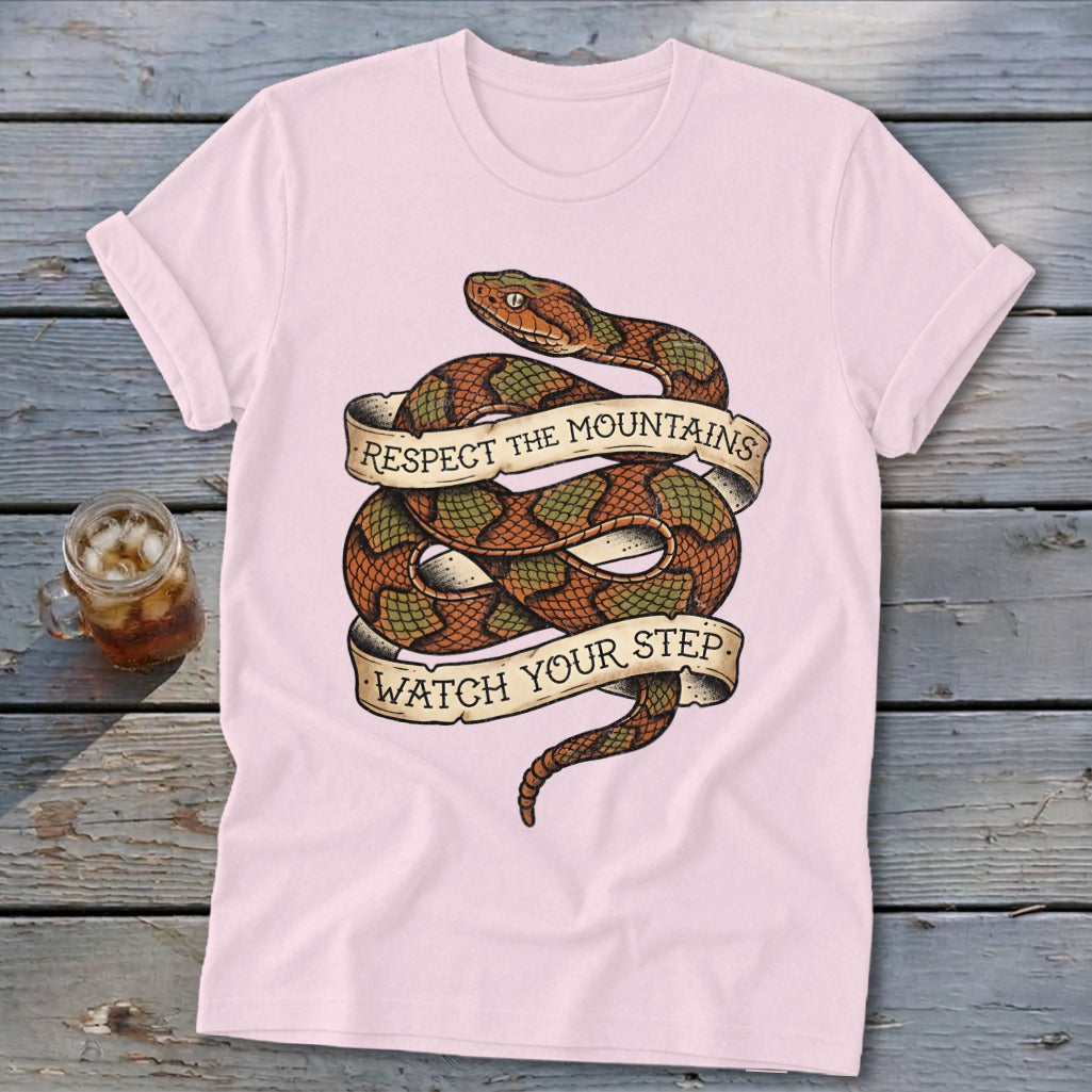Pink t-shirt with coiled snake graphic reading "Respect the Mountains Watch Your Step".