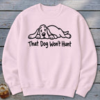 A light pink crewneck sweatshirt featuring a black cartoon hound dog graphic and the text That Dog Won't Hunt.